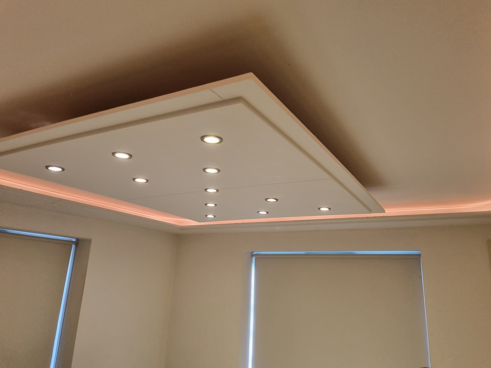 Stepped ceiling feature with recessed downlights and a warm LED cove strip