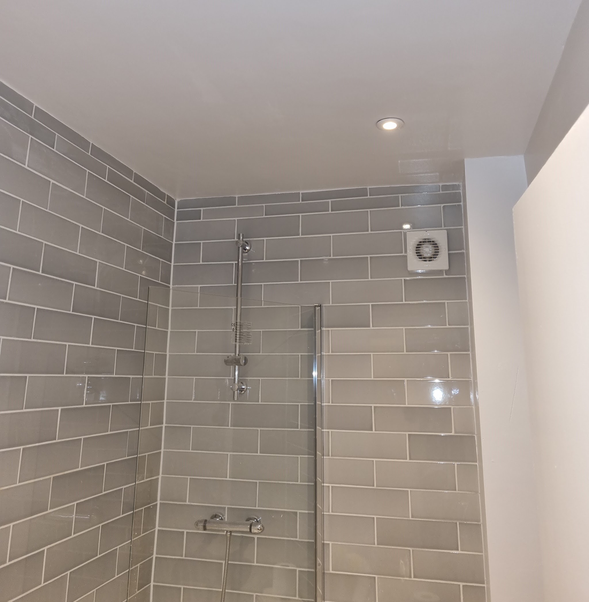 Tiled shower room with downlights and a wall extractor fan